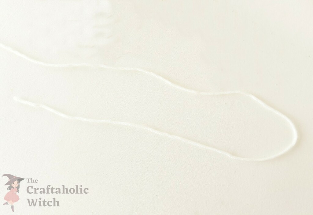 How to Make a Cute Easter Paper Garland (+ Free Template) 9 White yarn string prepared for assembling Easter paper garland