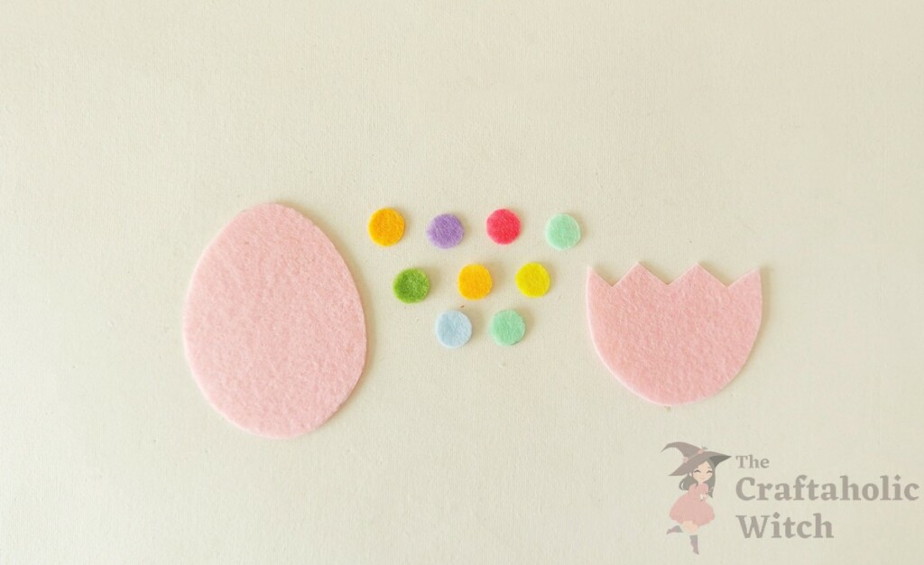 How to Make a Felt Easter Egg Pouch (With Free Template) 3 Craft materials for making a felt Easter egg pouch including egg shape, dots, and cracked top
